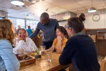 Happy young women with Down Syndrome in cafe with friends — Stock Photo