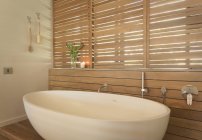 Замачивание труб и деревянных жалюзи в современной, роскошной внутренней ванной комнате витрины — стоковое фото