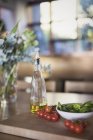 Ainda vida fresca, madura tomate cereja, manjericão e azeite na tábua de corte — Fotografia de Stock