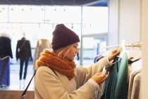 Giovane donna che fa shopping in negozio di abbigliamento, controllando il prezzo tag — Foto stock