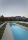 Luxury lap pool with view of mountains at dusk — Stock Photo