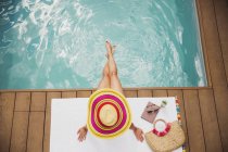 Mulher de chapéu de sol relaxante na piscina de verão — Fotografia de Stock