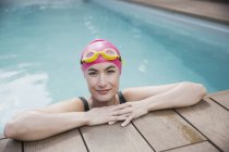 Retrato mujer confiada en gorra de natación y gafas en la piscina - foto de stock