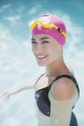 Portrait confident woman in swimming cap and goggles in swimming pool — Stock Photo