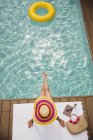 Жінка в сонячному капелюсі розслабляється, купається в літньому басейні — стокове фото