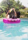 Mulher que relaxa, livro da leitura na jangada inflável na piscina ensolarada do verão — Fotografia de Stock