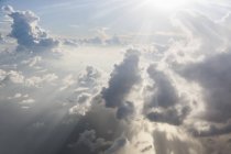 Aerial view sunbeams and fluffy white clouds in ethereal sky — Stock Photo