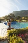 Serene woman in bathing suit relaxing at idyllic, tranquil swimming pool, Cape Town, South Africa — Stock Photo