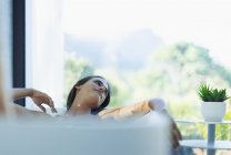 Serena mulher relaxante na banheira de imersão — Fotografia de Stock