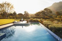 Woman walking at sunny, idyllic poolside, Cape Town, South Africa — Stock Photo