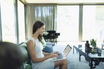 Geschäftsfrau arbeitet von zu Hause aus mit Laptop auf dem Sofa — Stockfoto