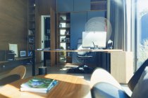 Ordenador en el escritorio en la oficina soleada, moderna casa - foto de stock