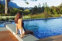 Жінка в купальнику, що розслабляється в ідилічному, спокійному басейні — стокове фото