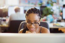 Портрет уверенной предпринимательницы, работающей за компьютером в офисе — стоковое фото