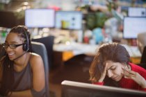 Стрессовая деловая женщина с головой в руках за компьютером в офисе — стоковое фото