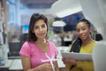 Portrait confident female engineers with prototype and robotic arm in office — Stock Photo