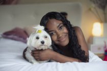 Portrait happy young woman with dog on bed — Stock Photo