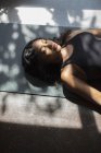Gelassene junge Frau liegt auf Yogamatte — Stockfoto