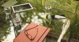 Eyeglasses and notebook on table with digital tablet and smart phone. - foto de stock
