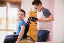 Portrait garçon avec trisomie 21 en fauteuil roulant — Photo de stock