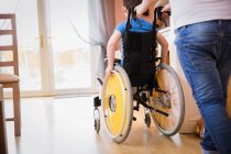 Мальчик толкает брата в инвалидной коляске — стоковое фото