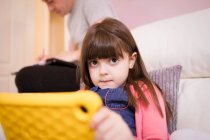 Porträt unschuldiges Mädchen mit digitalem Tablet auf dem Sofa — Stockfoto