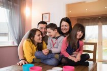 Porträt glückliche Down-Syndrom-Familie am Esstisch — Stockfoto