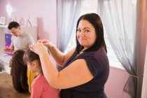 Portrait happy mother fixing daughter hair — Stock Photo