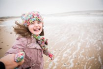 Retrato menina despreocupada feliz com Síndrome de Down correndo na praia de inverno — Fotografia de Stock