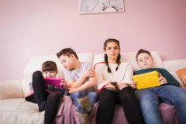 Down-Syndrom-Geschwister nutzen digitale Tablets auf dem Sofa — Stockfoto