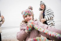 Портрет щасливої безтурботної дівчини в теплому одязі на зимовому пляжі — стокове фото