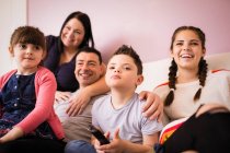 Счастливая семья смотрит телевизор на диване — стоковое фото
