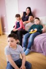 Niño con Síndrome de Down viendo la televisión con la familia en la sala de estar - foto de stock
