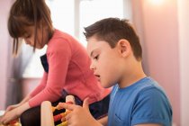 Curious boy with Down Syndrome playing with toy — Stock Photo