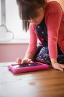 Девушка с помощью цифрового планшета за столом — стоковое фото