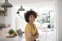Portrait happy young woman in kitchen — Stock Photo