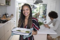 Porträt lächelt selbstbewusste junge Frau beim Kochen in der Küche — Stockfoto