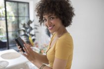 Portrait happy young woman using smart phone — Stock Photo