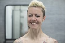 Портрет счастливой женщины с татуировками, смеющейся в ванной — стоковое фото