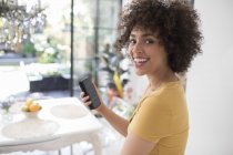 Portrait happy young woman using smart phone — Stock Photo