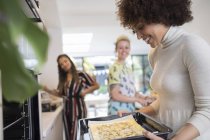 Young women friends cooking in kitchen — Stock Photo