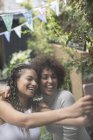 Happy carefree young women friends taking selfie with camera phone — Stock Photo