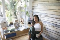 Mulher nova com café usando telefone inteligente em casa escritório — Fotografia de Stock