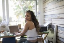 Портрет уверенной молодой женщины-фрилансера, работающей на ноутбуке в домашнем офисе — стоковое фото
