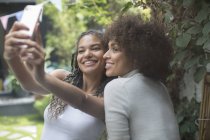 Beautiful young women friends taking selfie with camera phone — Stock Photo
