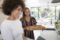 Happy young women friends cooking pizza fatta in casa in cucina — Foto stock