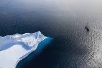 Schiff segelt am arktischen Eisberg vorbei auf dem sonnigen Atlantik Grönland — Stockfoto