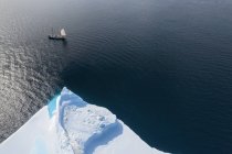 Schiff segelt am Eisberg vorbei auf dem sonnigen Atlantik Grönland — Stockfoto