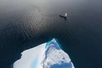 Drone punto di vista nave che naviga oltre iceberg sull'oceano soleggiato Groenlandia — Foto stock