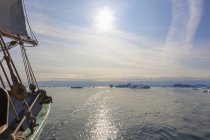 Barca a vela sul soleggiato Oceano Atlantico con iceberg in fusione Groenlandia — Foto stock